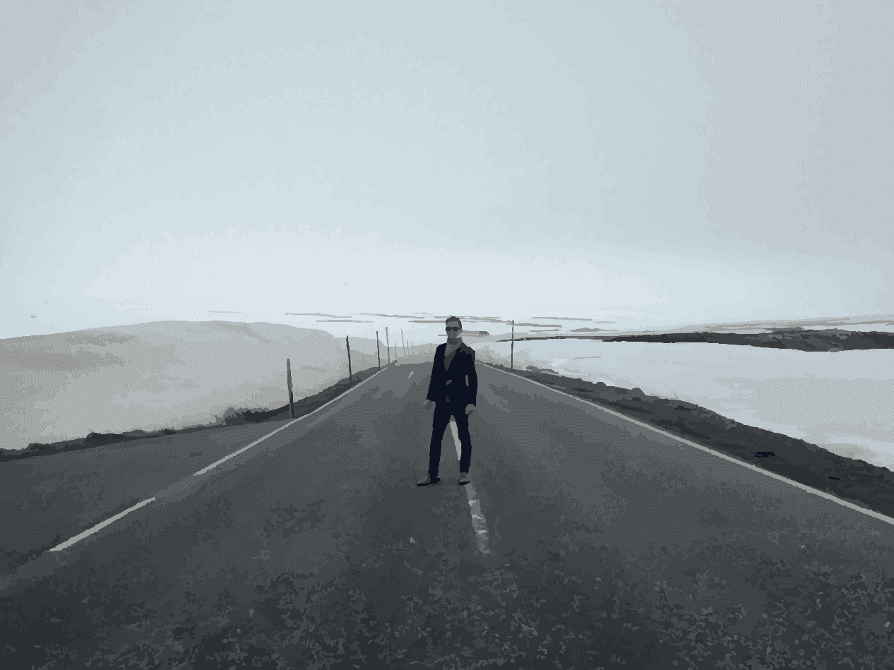 the author standing in the middle of a desolate road with snowbanks to either side